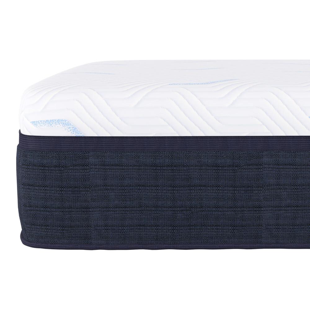 A close-up of Southerland's Palisades Mattress corner shows a textured dark blue side panel and white top with a subtle wave pattern, reflecting the renowned comfort with its soft, cushioned fabric.