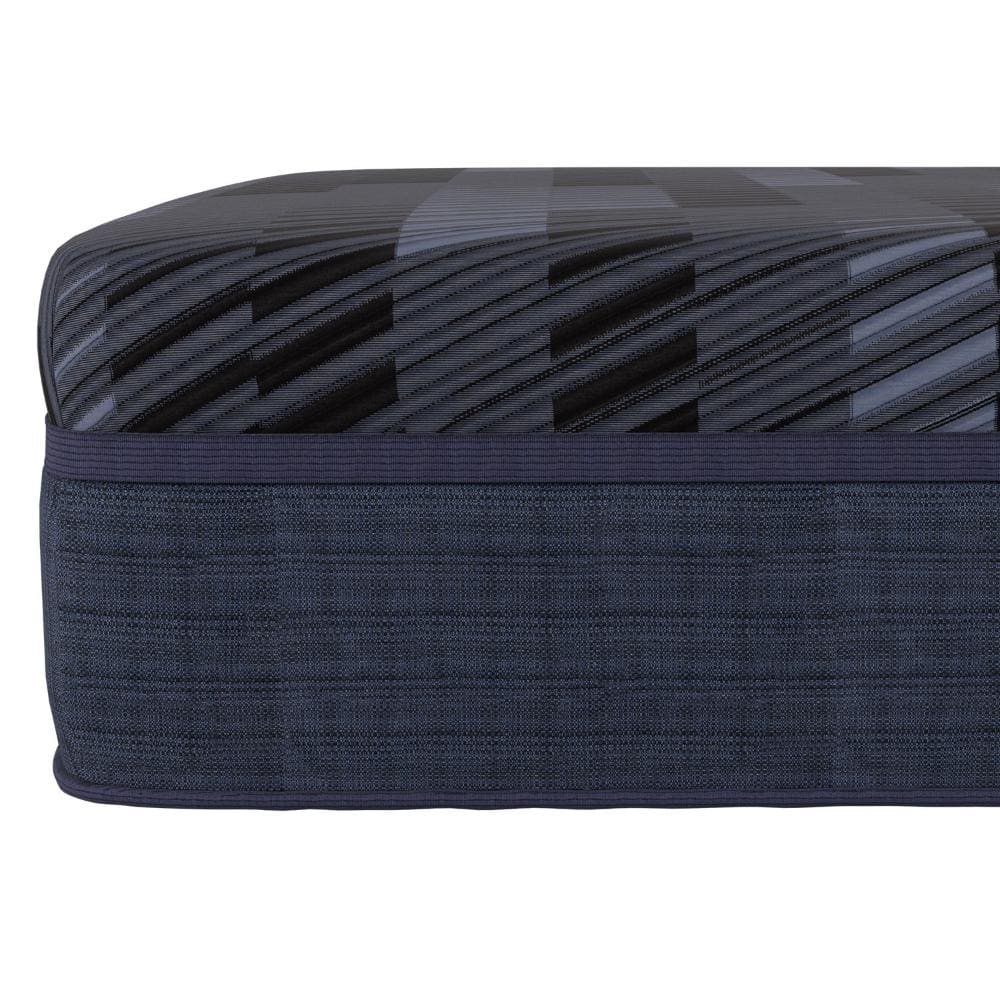 Close-up of the Talliston Mattress corner, revealing a dark geometric pattern with diagonal stripes on top and textured dark blue fabric sides. The edge is smoothly finished with piping, showcasing Southerland's craftsmanship.