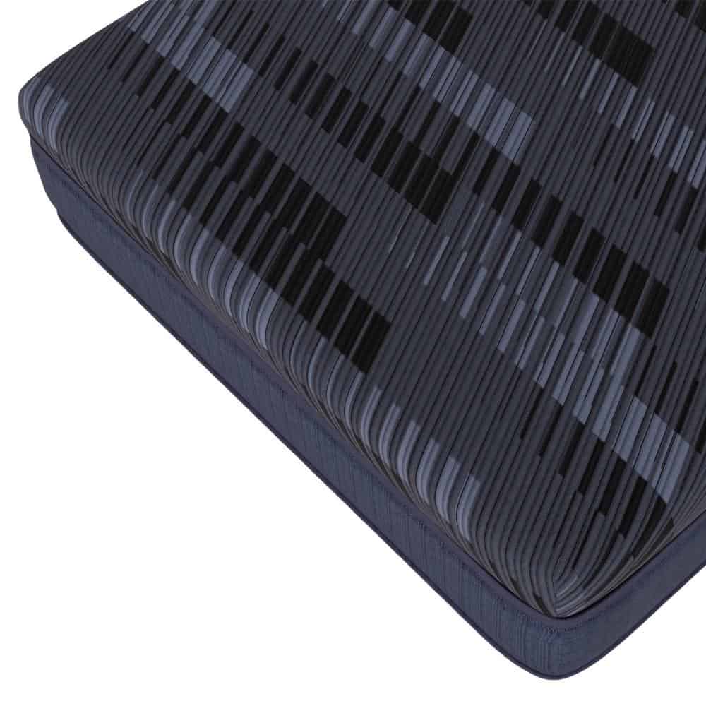 A corner of Southerland's Talliston Mattress features a textured, dark blue cover with alternating light and dark diagonal stripes, offering a soft and cushioned surface ideal for restful sleep.