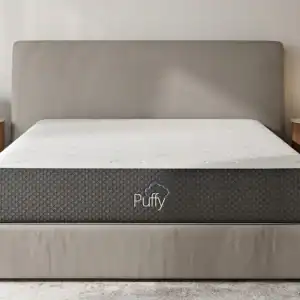 Puffy brand mattress on bed in neutral bedroom setting.