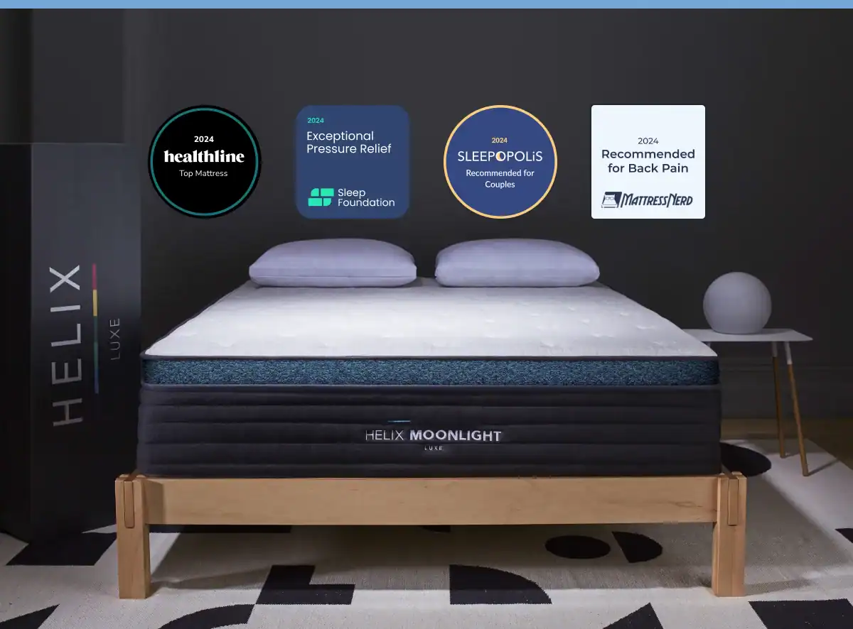 A modern and stylish bedroom showcasing the HELIX MOONLIGHT LUXE luxury mattress, decorated with awards for exceptional pressure relief, couple suitability, and back pain recommendation, suggesting a focus on comfort.