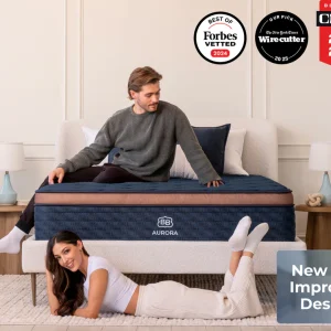 A man sits on a bed while a woman lies playfully underneath, both smiling. The Brooklyn Aurora Luxe Cooling bed features its new and improved design, plus awards from Forbes, Wirecutter, and CNET for its cooling innovation.