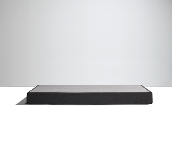 A low, rectangular, minimalist black platform bed featuring the Southerland 9" Semi Flex Box Spring on a clean white surface against a plain light gray background. The design is sleek with no visible legs or headboard, emphasizing a modern, uncluttered aesthetic.