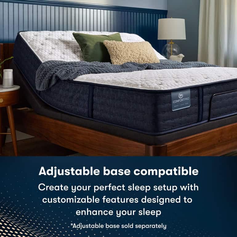 Image of a comfortable adjustable bed setup, featuring a raised head section. The bed is well-dressed with white and grey bedding, several pillows in green and brown shades, and a textured blanket. A side table with a lamp is visible nearby. Text reads: "Adjustable base compatible Serta iComfortPro Mattress: Chelsea Medium. Create your perfect sleep setup with customizable features designed to enhance your sleep experience. *Adjustable base sold separately.