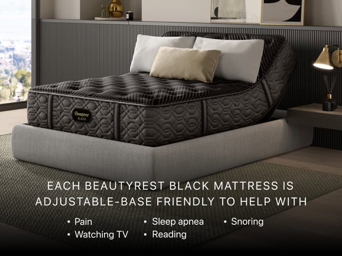 A modern bedroom showcases an adjustable bed adorned with a firm pillow top Beautyrest Black® Series One 14.25" mattress, which can be elevated at both the head and foot. The room is elegantly styled with a gray padded bed frame, sleek black paneling, and a lamp placed on a side table. Text emphasizes the advantages of using an adjustable-base mattress.