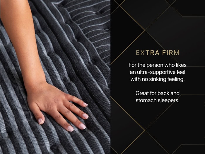 A hand presses down on a Beautyrest Black® Series One 14.25" Firm Pillow Top Mattress featuring a gray and black striped fabric. Text on a black background reads: "Extra Firm—For the person who likes an ultra-supportive feel with no sinking feeling. Great for back and stomach sleepers.