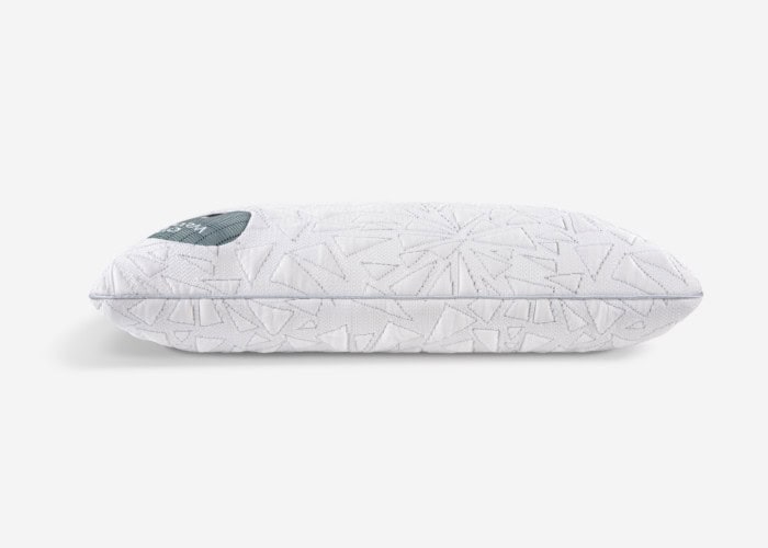 A rectangular, white Storm Performance® Pillow with a textured pattern characterized by abstract shapes. A small, dark-colored tag is located in the upper left corner. The plain, light-colored background ensures that the Storm Performance® Pillow remains the focal point of the image.