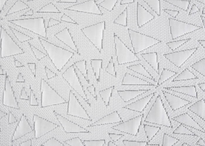 The Storm Performance® Pillow showcases a textured white fabric pattern with an abstract design of interlocking triangles and geometric shapes, enhanced by a mix of raised and recessed areas for added visual dynamism.