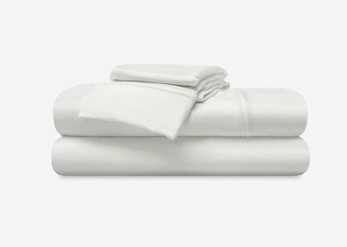 A neatly folded Hyper-Cotton Sheet Set (Copy), including a fitted sheet, a flat sheet, and two pillowcases, arranged in a stack against a plain white background. The fabric appears smooth and clean, suggesting a fresh and crisp texture.