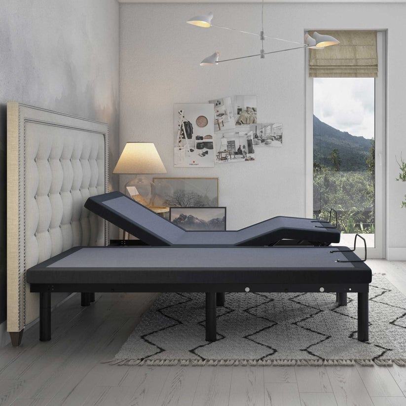 A modern bedroom showcases the Bed Tech 6500 Adjustable Base with a tufted headboard. It features advancements like a lamp, abstract art, and a large window for mountain views. The room's neutral palette seamlessly blends gray and beige tones.