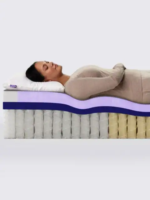 A woman lies on her back with hands on her stomach on a PurplePlus Mattress, shown in cross-section to highlight its multiple inner layers and coils designed for ultimate comfort.
